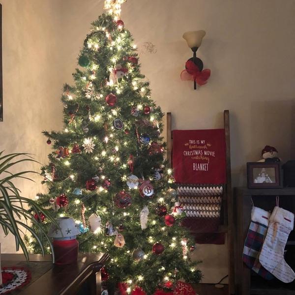 A Christmas tree with white lights in a living room full of Christmas decorations