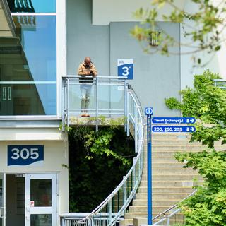 A person stands at the top of the spiral steps outside the VIU Library