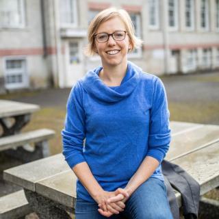 Alison Garnett sitting on table and smiling at camera