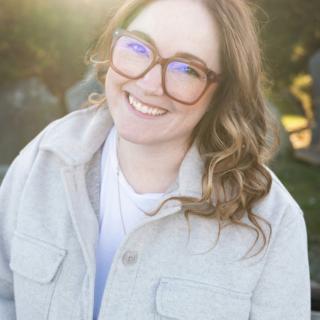 Ashley Kuramoto smiles with a natural and/or garden background