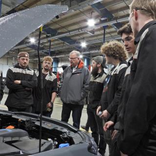 students and Minister Ralston gathered around a car