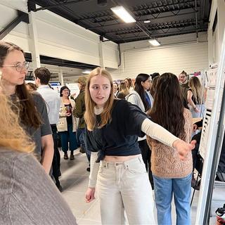 a student points at a poster board during the create conference
