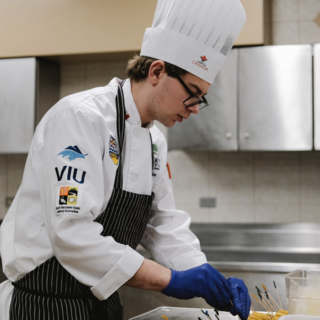 Simon Martin preaparing food in a professional kitchen.
