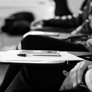 Hands on a desk with a pencil and paper