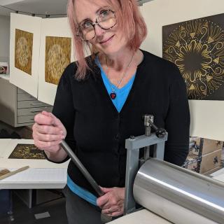 Mary Anne Molcan stands by her print press.