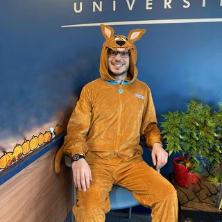 A man in a rabbit costume sits under a Vancouver Island University sign