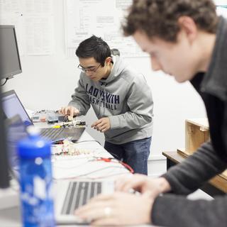 Two VIU Engineering students work on computer equipment in a lab.