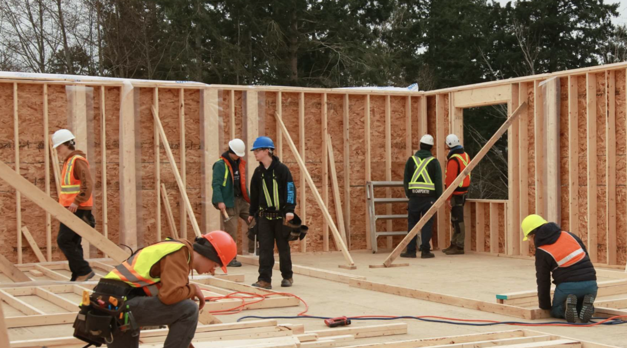 Carpentry students working working on a housing construction site.