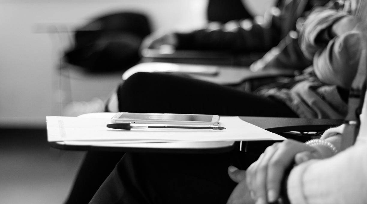 Hands on a desk with a pencil and paper