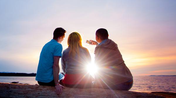 Three students backlit by the sun