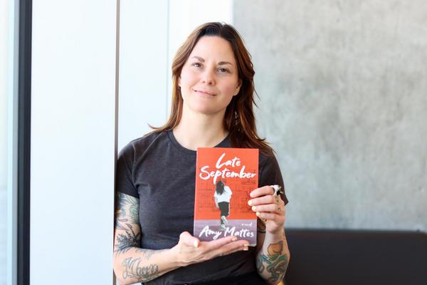 Amy Mattes holds up a copy of her book, Late September.