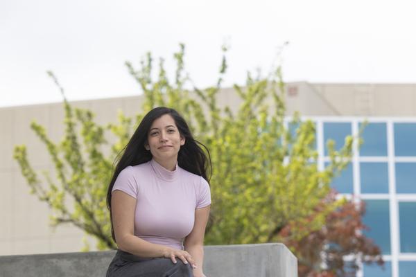 Student sitting on stairs, smiling at camera