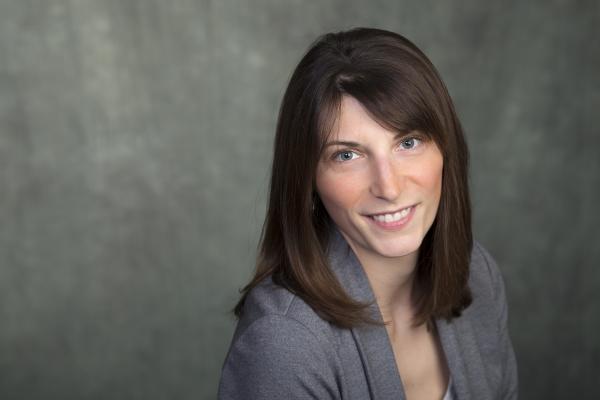 Headshot of Dr. Lindsay McCunn, wearing a grey blazer and smiling.