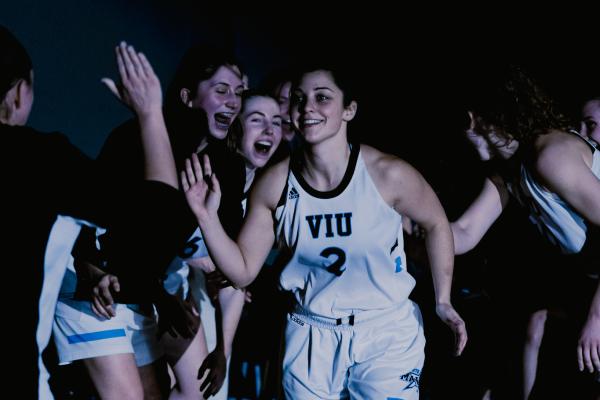 Amber runs by other basketball players giving high fives