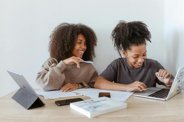 Two students studying together with their laptops open