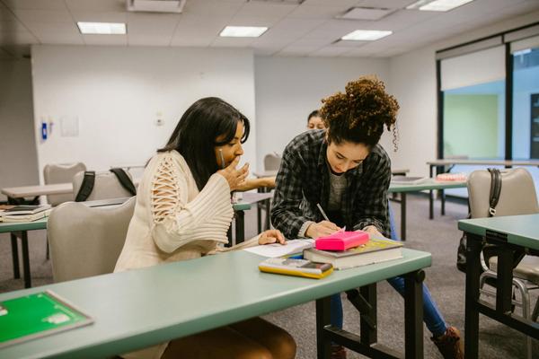 One friend helps another with homework