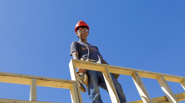 A carpenter up high building a frame