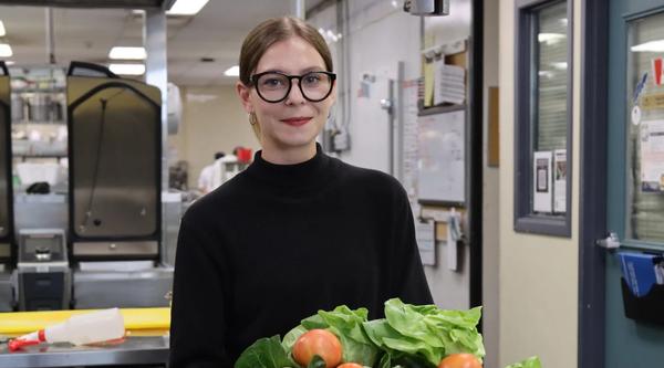 Isabelle with fruits and veggies piled in front of her