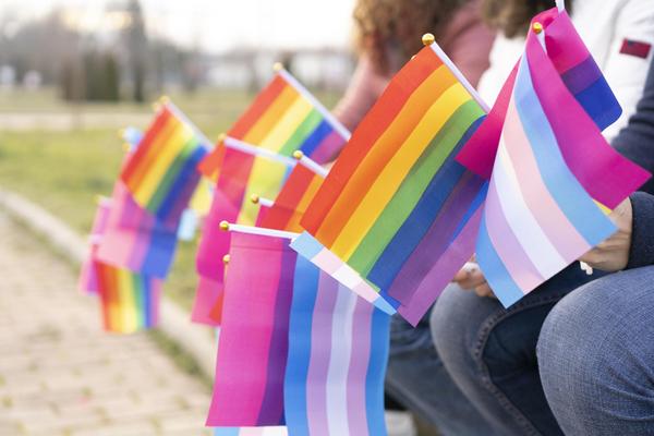 A closeup of multiple trans and pride flags.