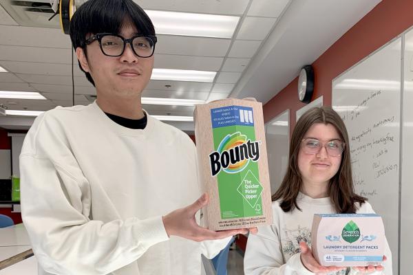 Nathan Pham and Kiara White hold their redesigned product packaging.