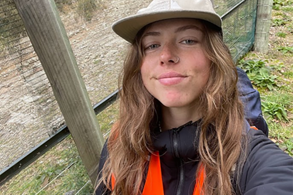 Georgia stands in front of a fence