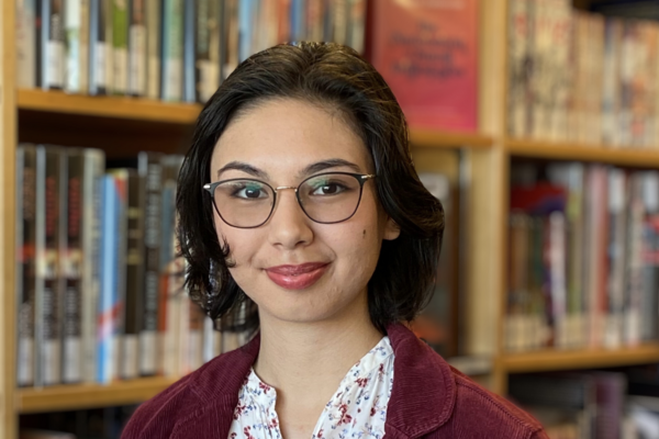 Chiara Sedola standing in front of a bookshelf and smiling at the camera