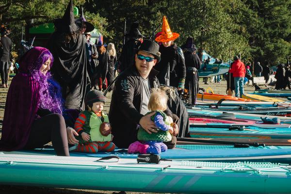 People dressed in costumes sitting on paddleboards at Westwood Lake