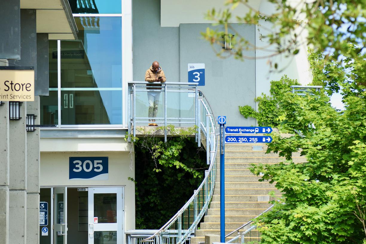 A person stands at the top of the spiral steps outside the VIU Library