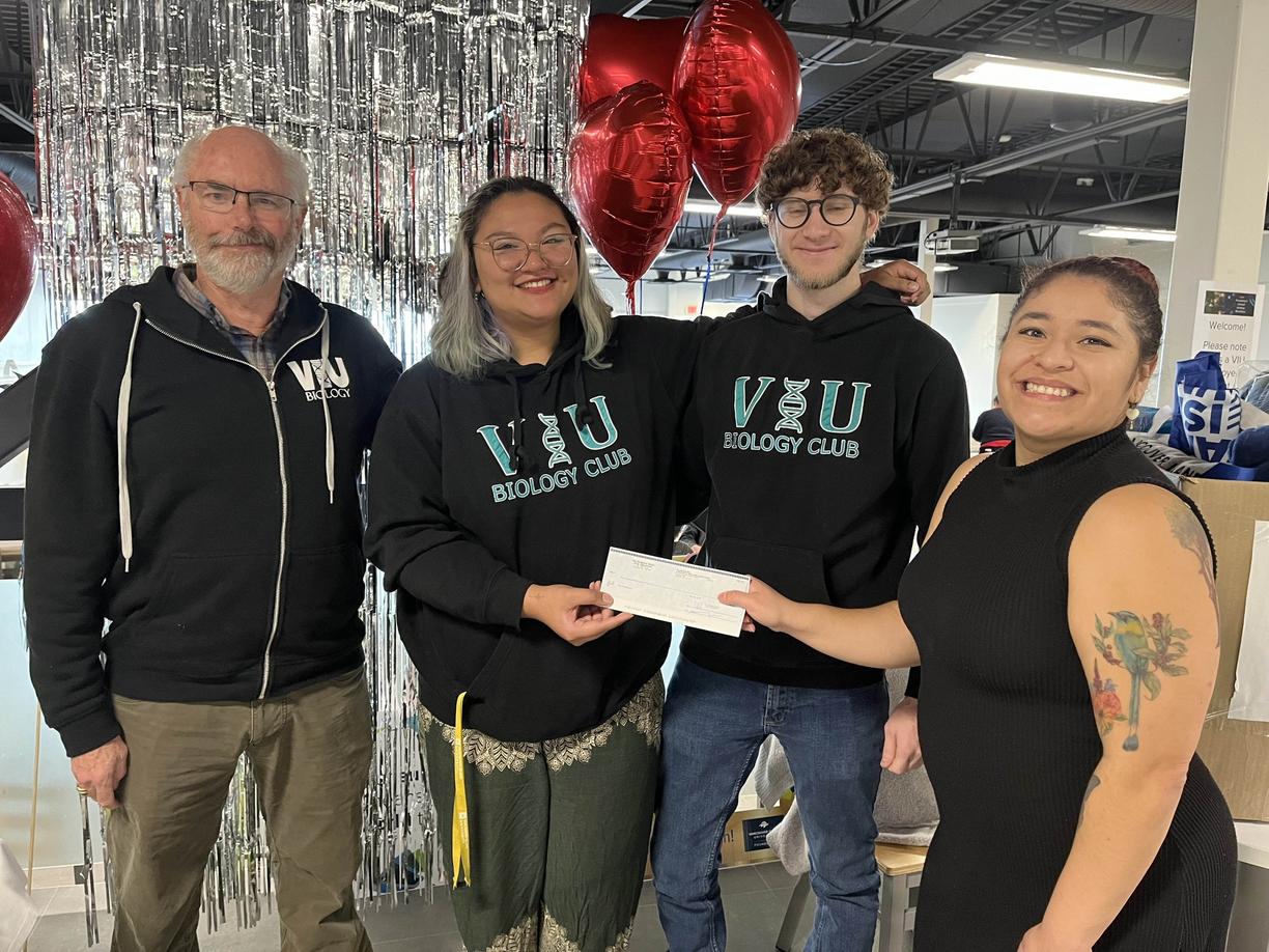 Group of four people holding a cheque