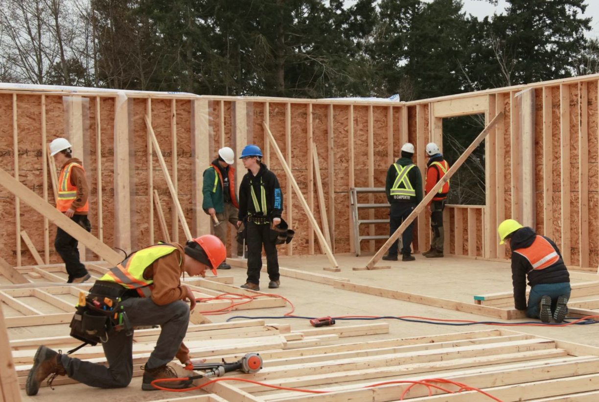 Carpentry students working working on a housing construction site.