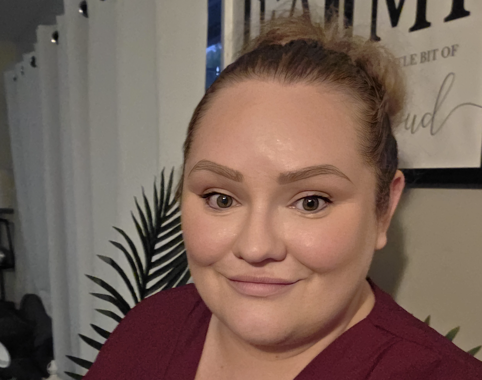 Kylie smiling at the camera wearing a red shirt.