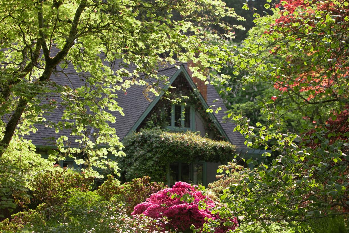 Milner House framed by blooming flowers and foliage