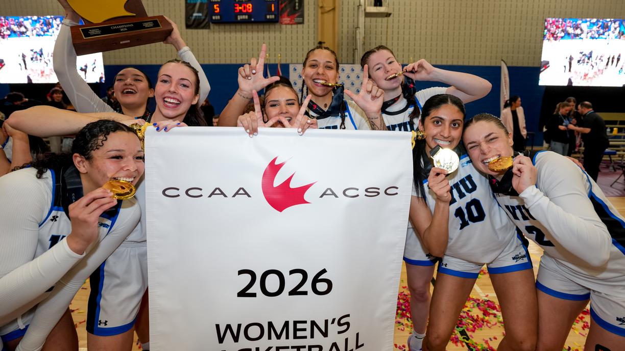 the women's basketball team holds up gold medals