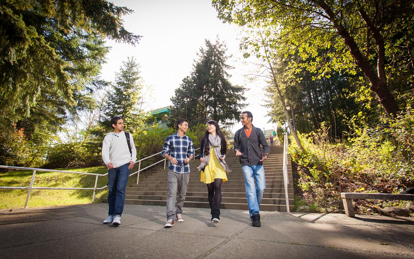 Four students walk down the stairway near the Nanaimo campus Quad.