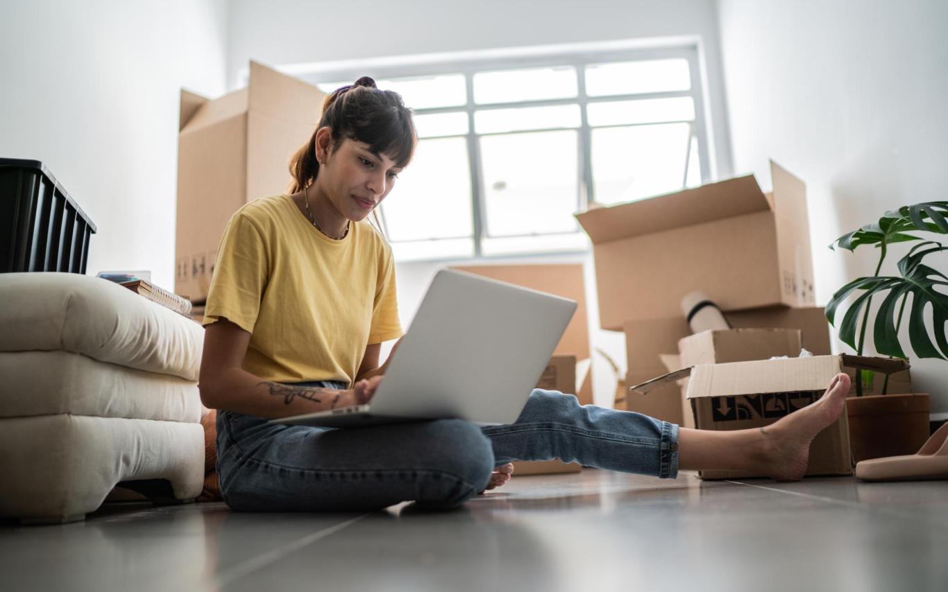 A student looks at a laptop screen surrounded by boxes