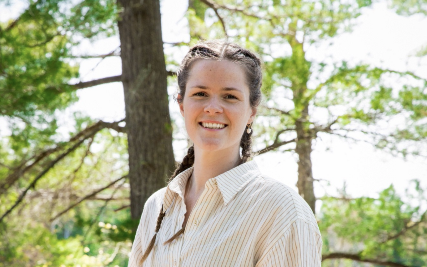 Laura Hutchinson smiling at the camera with trees in the background.