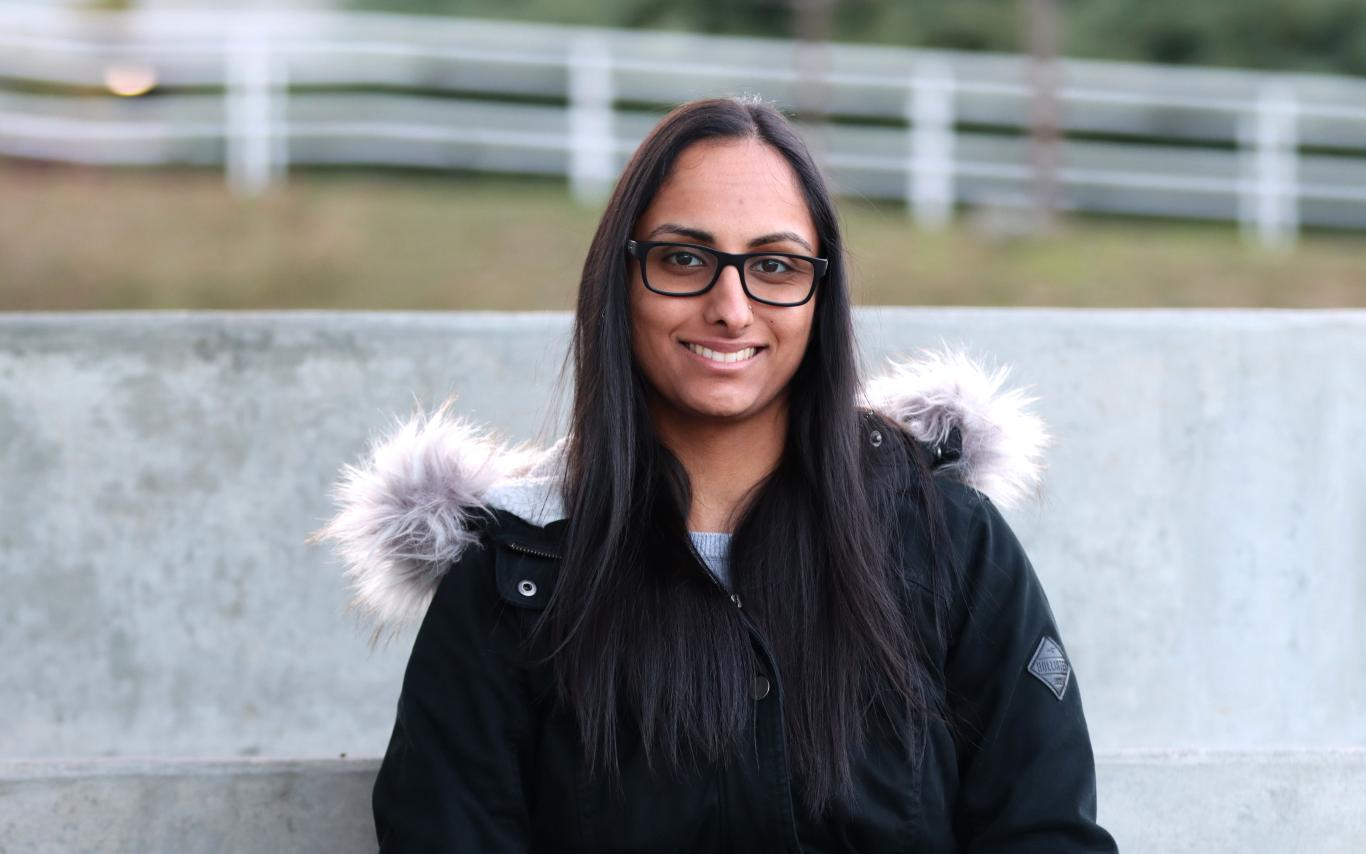 Portrait of Nina Gill sitting and smiling at the camera